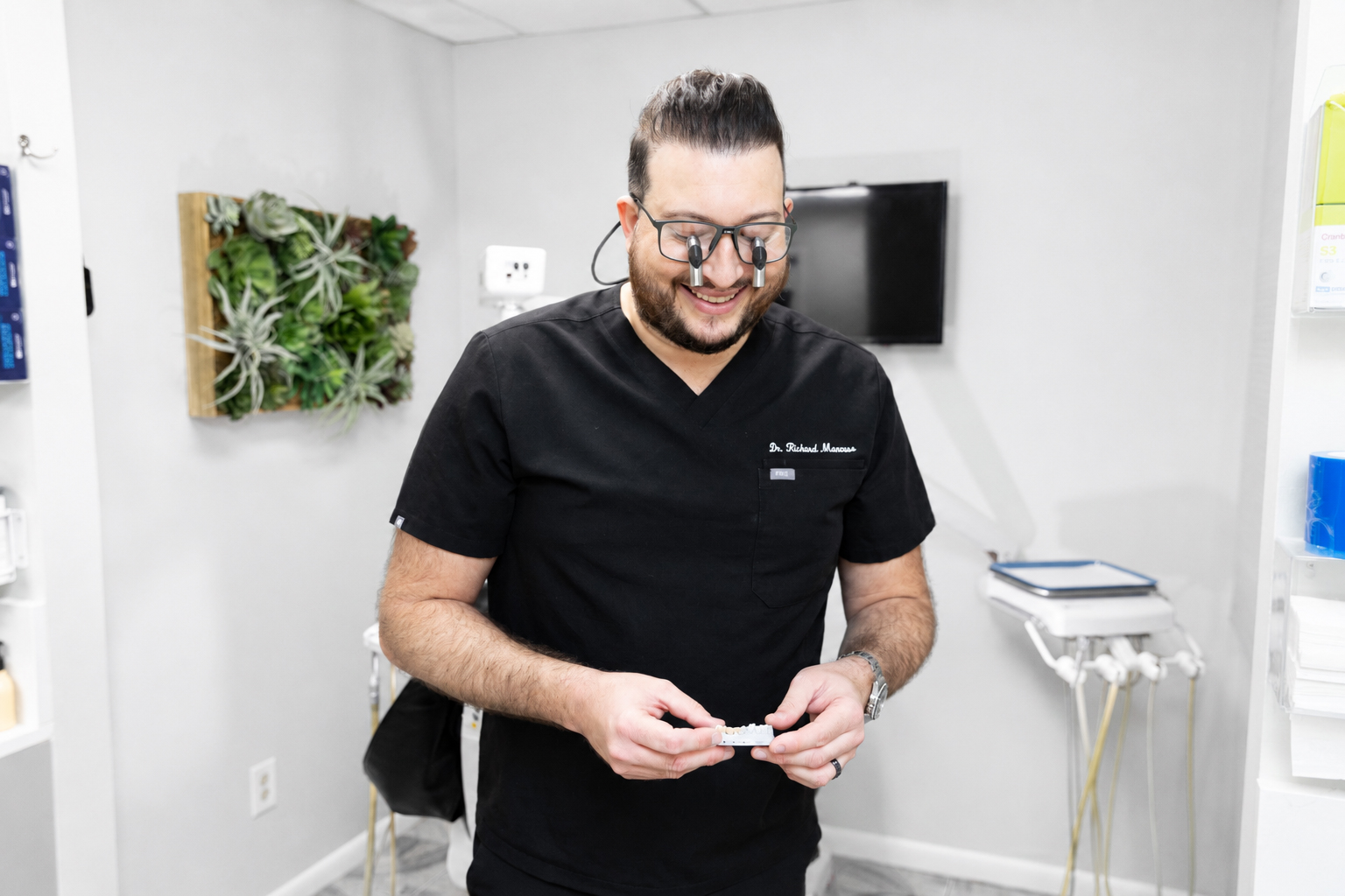 Patient checking improved smile in mirror after porcelain veneers treatment in Carrollwood Village, FL
