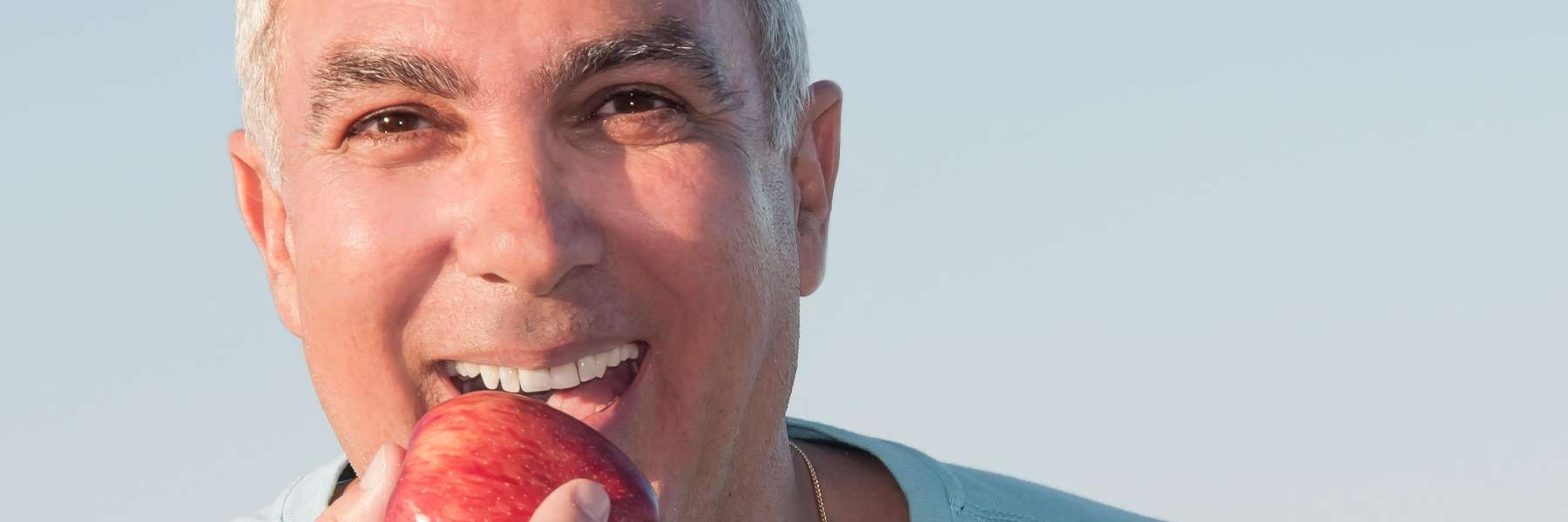 A man eating an apple after emergency treatment at Carrollwood Village Dental