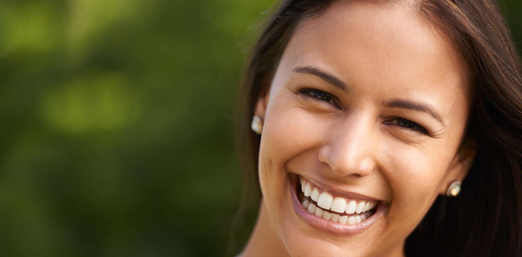 An image of a woman smiling after getting teeth whitening service in Tampa, FL