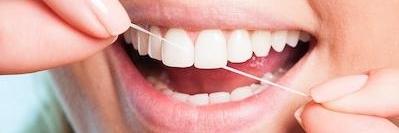 Woman flossing her teeth in Tampa, FL