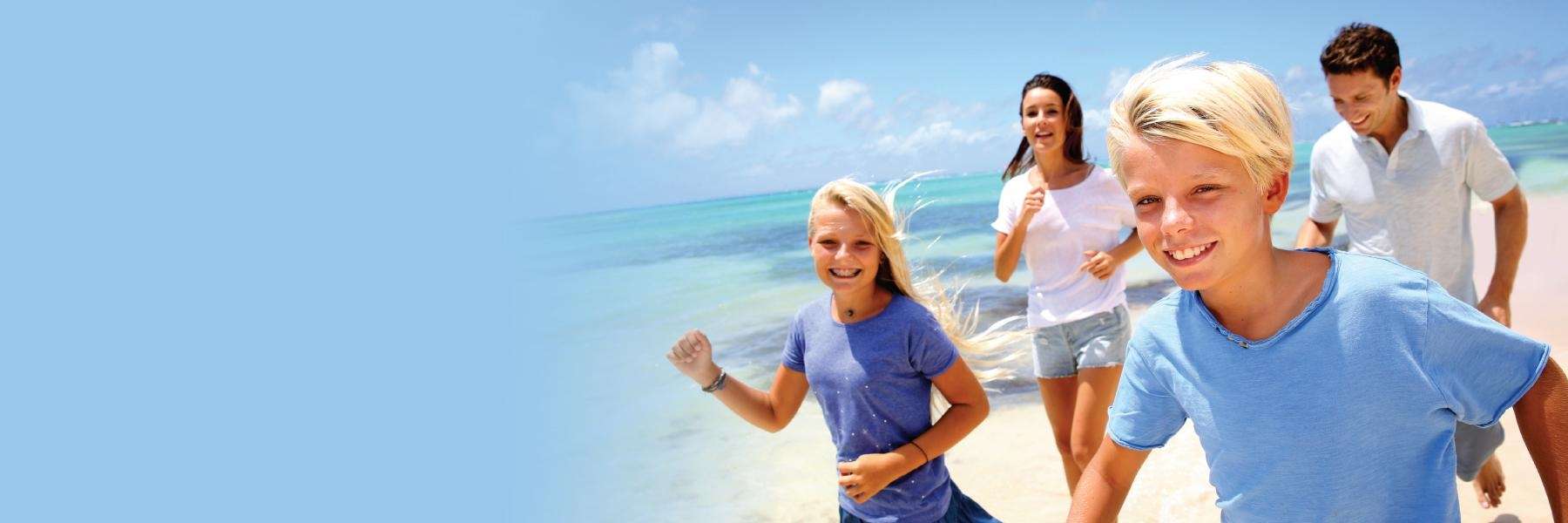 Family playing on the beach after general dentistry in Tampa, FL