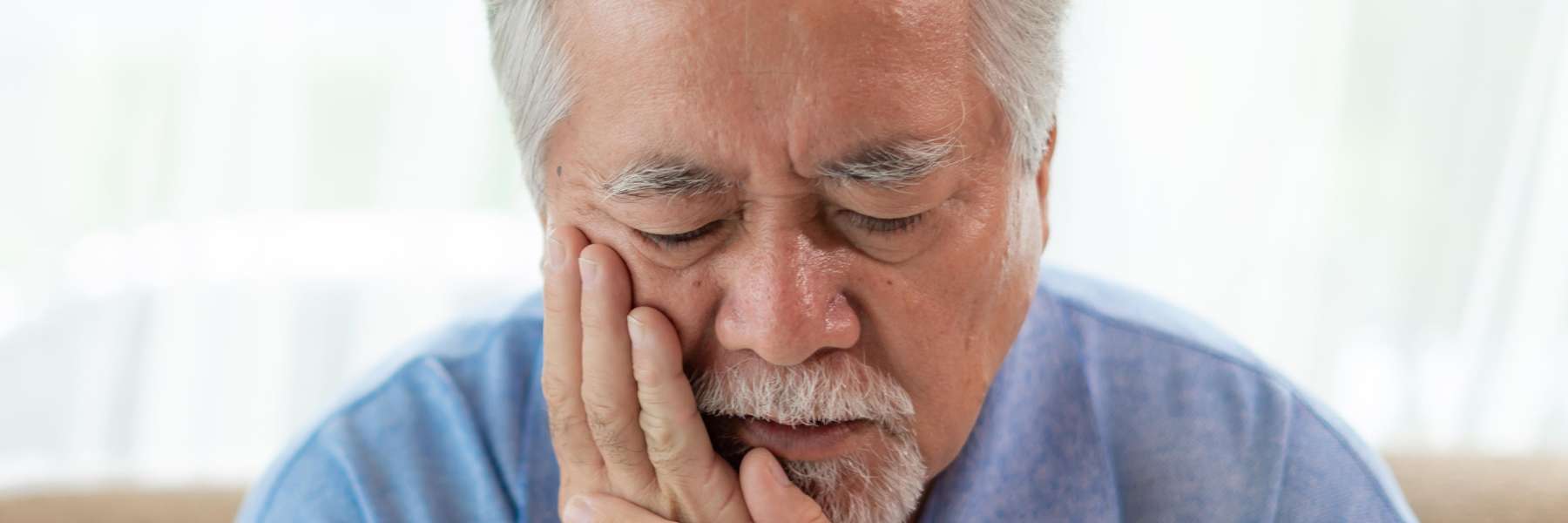 Patient holding his jaw due to migraines in Tampa, FL